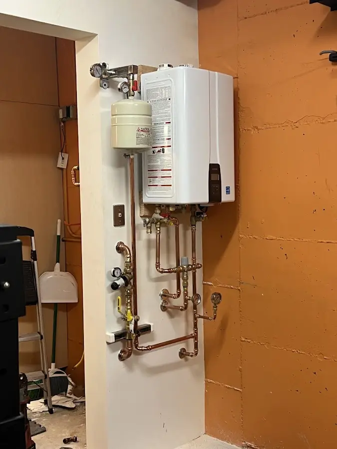 Plumbing technician inspecting water heater connections in Aldine